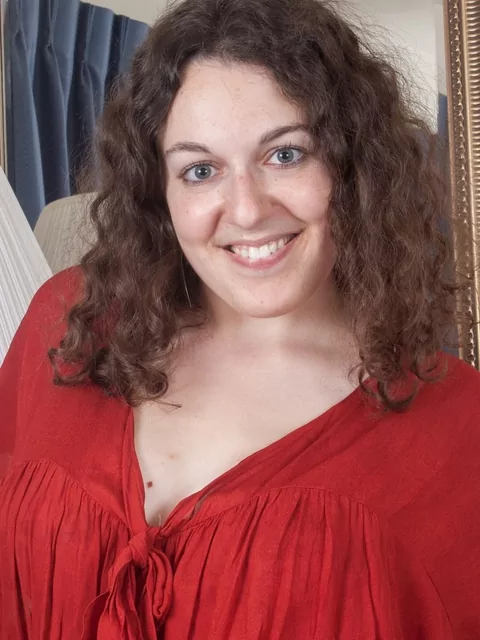 Ragazza paffuta e dai capelli ricci che mostra la sua nuditΓ